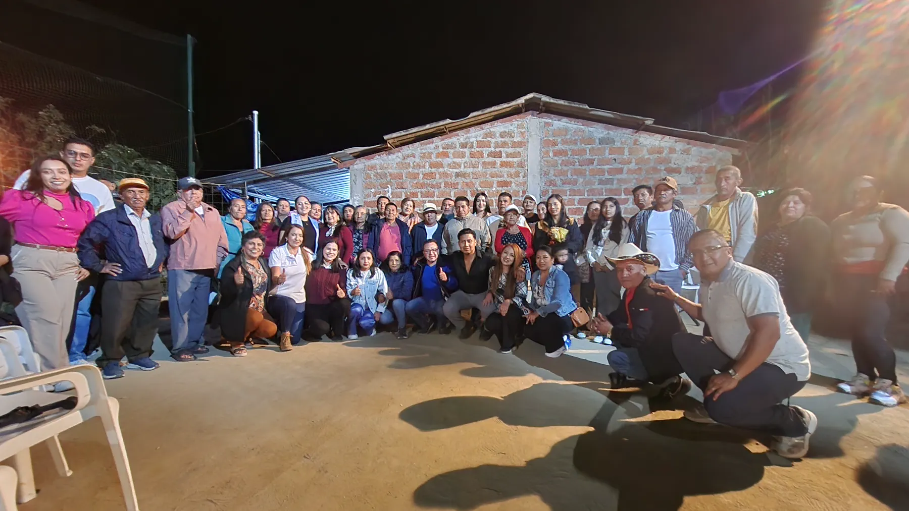 Amplio grupo de vecinos y voluntarios reunidos en un patio comunitario