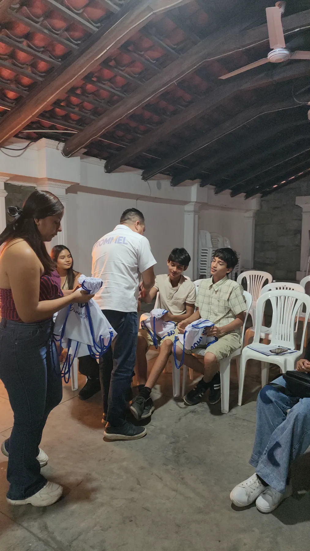 Entrega de un recuerdo a jóvenes durante un encuentro vecinal