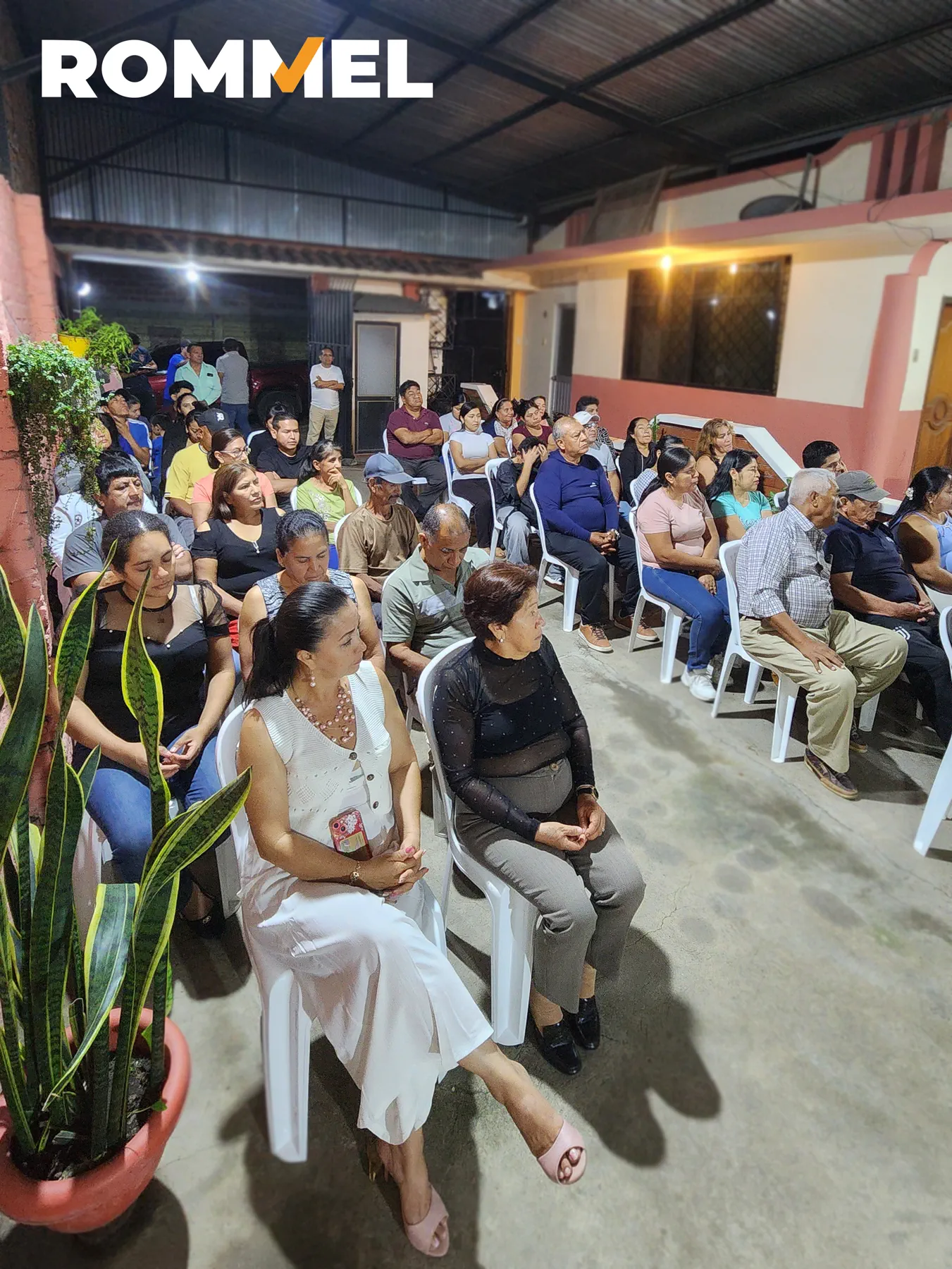 Vecinas y vecinos reunidos en un espacio comunitario cubierto