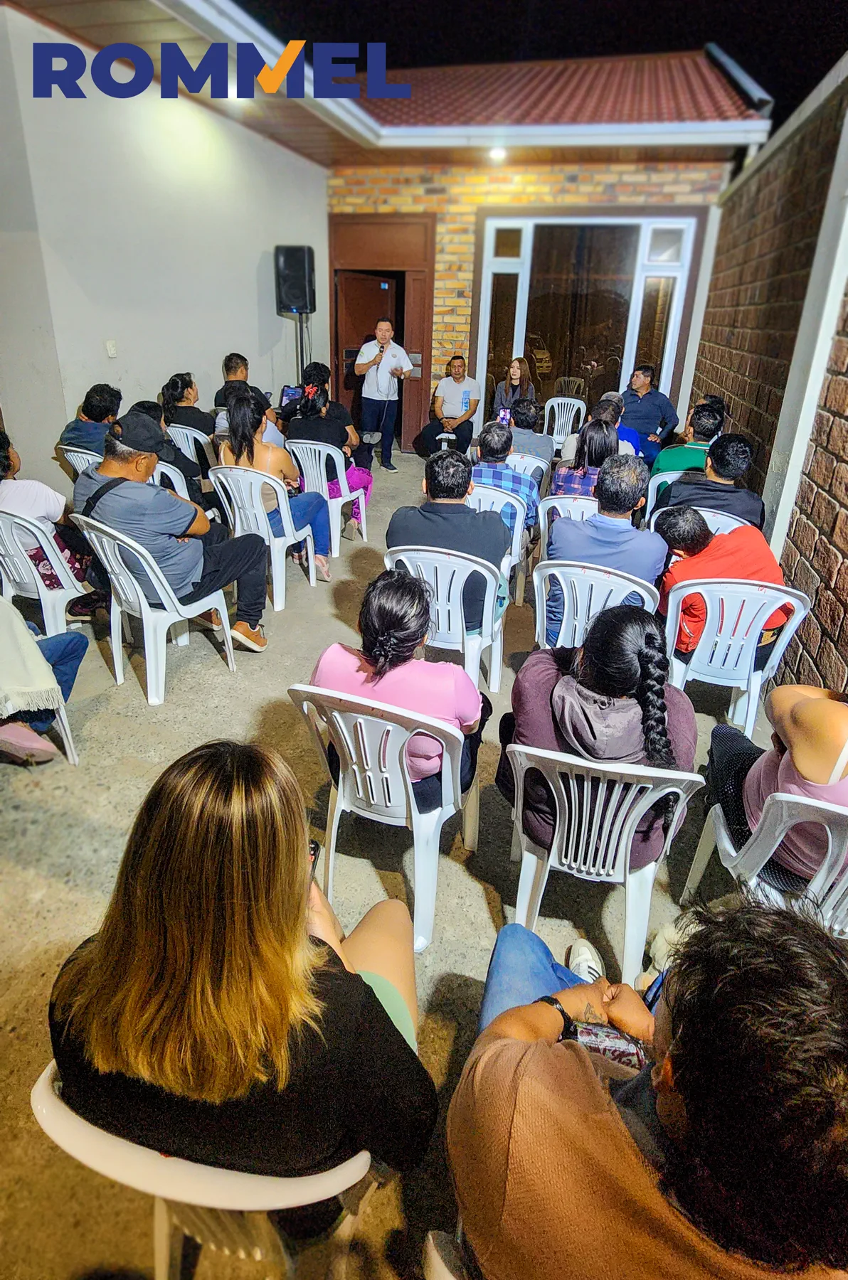 Público reunido en un patio durante una conversación comunitaria