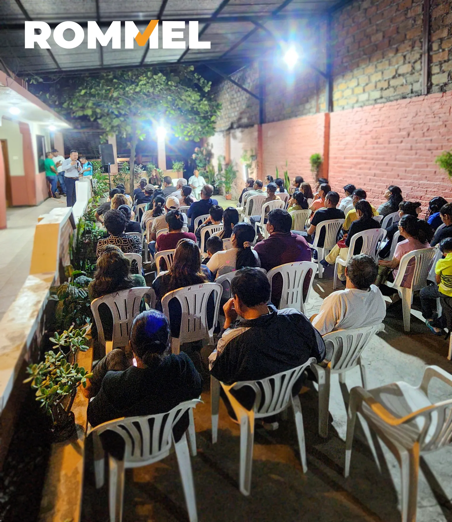Grupo numeroso de personas participando en una reunión barrial